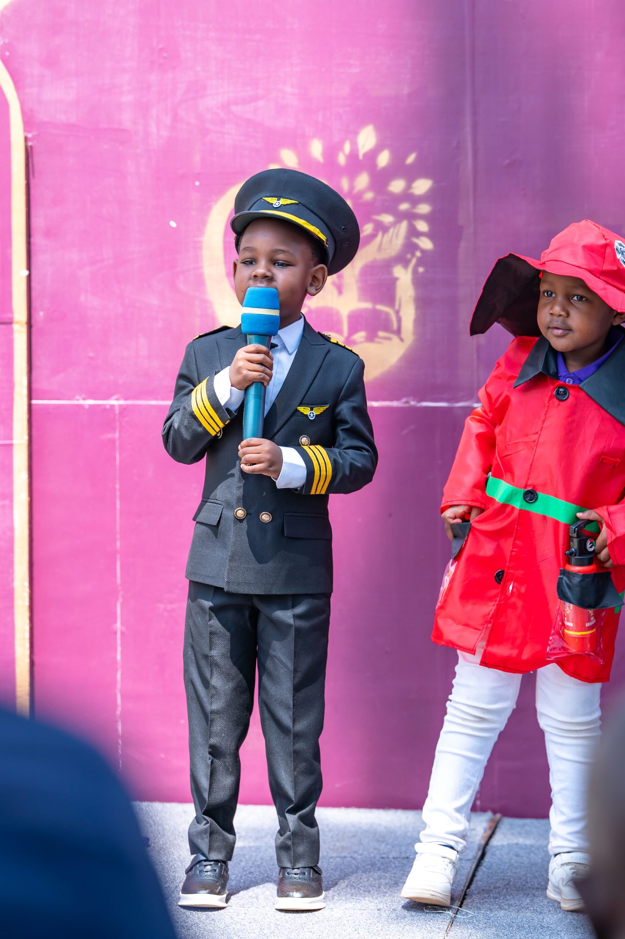 Young student in pilot costume speaking at graduation ceremony